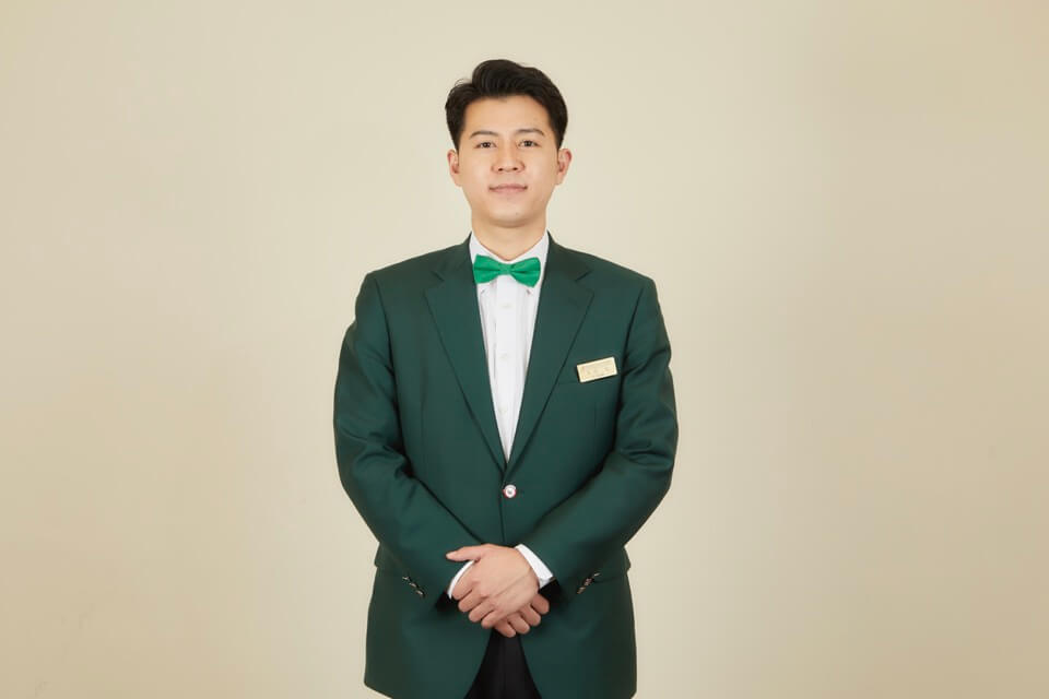 収穫したタケノコを背負う大住総支配人